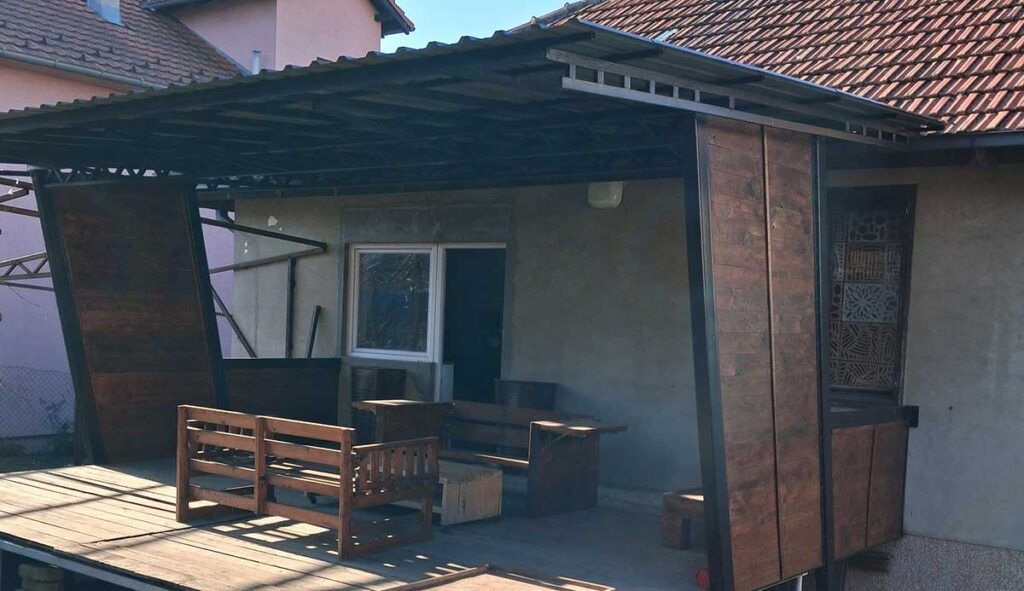 Freestanding covered porch with metal roof supported by steel square tubing frame